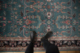 An overhead perspective of the traditional Sarouk design with dusty teal, blush, and black floral details.