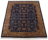 Angled view of a vintage Indian carpet highlighting the Arts and Crafts style border and lush pile.