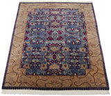 Angled view of a vintage Indian rug with a blue floral field and wide, scrolling beige border.