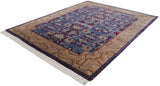 Angled view of a vintage Indian carpet with a beige vine border framing its blue and red floral field.