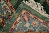 Folded corner of a vintage runner showing its full pile, intact selvage, and scrolling palmette border.