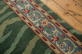Close-up showing the runner's blue and red floral border beside the plush striated green pile.