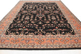 Angled view of a vintage Sarouk carpet's sprawling design and dense pile on a black field.