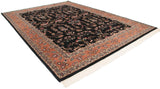 Angled view of a plush Indian Sarouk carpet showing its black field and ornate terracotta border.