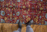 Vintage Indian Arts and Crafts rug with wine red field and gold border motifs.