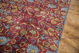 Indian Arts and Crafts rug with wine red field, scrolling leaves, and gold border.