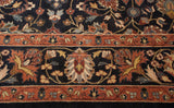 Close view of the hand-knotted Yezd carpet's terracotta border and floral navy field.