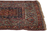 Wide main border and corner fringe on an antique Fereghan rug with its classic green shades.
