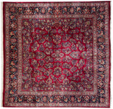 Vintage Sarouk carpet with gem-tone floral sprays on a ruby red field and navy border.