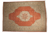 Vintage Tabriz carpet with a starburst medallion on a terracotta field and ornate ivory and slate blue spandrels.