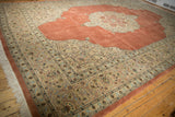 Ornate corner spandrels with scrolling arabesques on a terra cotta and ivory Tabriz carpet.