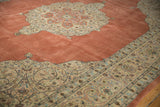 Angled view across the plush terra cotta field to the ornate ivory spandrel of a Tabriz carpet.