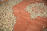 Ornate corner spandrel with scrolling arabesques on the warm terra cotta field of a vintage Tabriz rug.