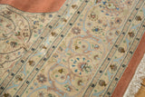 Corner of a vintage Tabriz rug showing the ornate border detail and plush ivory fringe.