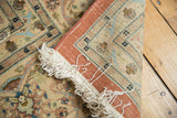 Folded corner of a vintage Persian rug revealing the hand-knotted weave and original ivory fringe.