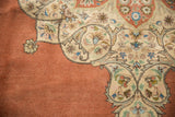 Ornate corner spandrel with scrolling arabesques against the terra cotta field of a vintage Tabriz carpet.