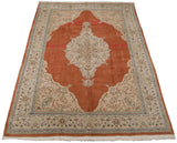 Vintage Tabriz carpet from a low angle, showing its terra cotta field and ivory medallion.