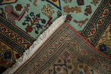 Mint green geometric finned bird, fringe, and hand-knotted back of vintage Ardebil carpet.