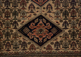 Detail of a vintage Ardebil rug's navy medallion and its pictorial field of birds and shrubs.