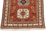 Stylized bird motifs within the geometric border and ivory fringe of a vintage Persian Meshkin carpet.