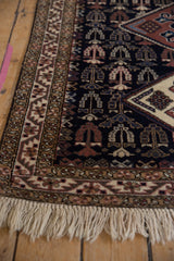 Vintage Ardebil rug corner with geometric borders, a navy blue field, and full ivory fringe.