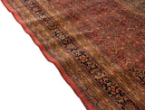 Wavy side edge detail of a vintage Indian Bijar rug, highlighting dusty brick red selvage.