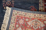 Vintage Laristan carpet corner with light fringe, dusty blue border, and red floral field.