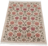 Angled view of the vintage Indian carpet, highlighting its full, even pile and repeating floral lattice design.