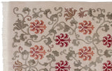 Plush hand-knotted pile showing red lotus flowers and scrolling silver vines on an ivory field.