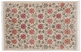 Close-up of the plush wool pile showing red and terracotta lotus flowers with green scrolling vines.