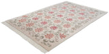 Angled view of a vintage Indian rug with an Arts and Crafts floral lattice design.
