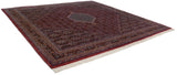 Securely finished side and pristine white fringe of the dusty raspberry Indian Bijar carpet.