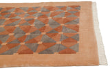 Geometric beige, terracotta, and oxidized silver pattern on Indian Art Deco carpet corner.