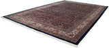 Full length of a vintage Indian Bijar carpet showing its dense navy floral field and complex border.