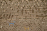 Slate blue and dusty gold art silk animals on a textured, neutral-toned folk art carpet.