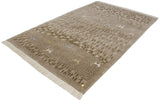 Angled perspective of a beige Indian folk art rug with a sculpted pile and ivory fringe.