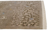 Corner of a folk art rug showing textured rocky areas, spiral motifs, and its original ivory fringe.