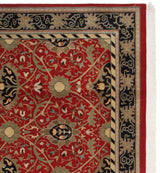 Corner of a vintage Indian carpet with a navy blue border featuring beige Arts and Crafts vinery.