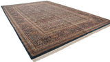 Vintage Indian carpet with allover paisley botehs in navy and red, shown from a low corner perspective.