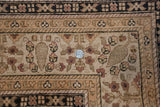 Traditional Indian Tabriz carpet corner with intricate ivory, beige, and raspberry floral arabesques, coin for scale.