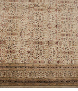 Indian Tabriz design rug border showing intricate beige, ivory, and dusty raspberry floral motifs.