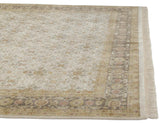 Corner of the hand-knotted Agra carpet showing the intricate Herati border and neat ivory fringe.