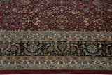 Detailed floral motifs in the dark navy blue border of the Indian Tabriz design carpet.