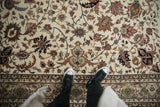 Looking down at the full wool pile of an Indian Isfahan carpet with scrolling vinery and floral motifs.