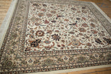 An Isfahan design carpet's corner showing scrolling vinery, a multi-band floral border, and ivory fringe.