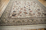 A low angle across the plush wool pile of an Isfahan carpet, detailing the corner border with turtle design samovars and ivory fringe.
