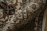 Soft folds of the Indian carpet showing the plush wool pile and intricate floral vinery border.