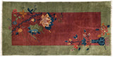 Potted tree of life motif on burgundy and celadon Art Deco rug corner.