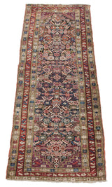 Hand-knotted antique Caucasian runner border detail with geometric starburst and serrated leaf patterns.