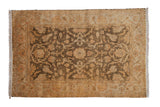 Gold wash Indian Oushak design rug with an allover floral pattern in dusty gold and olive green.